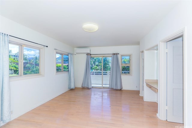 736 Ulili St, Honolulu, HI 96816 - unfurnished room with an AC wall unit, light wood-style flooring, and baseboards