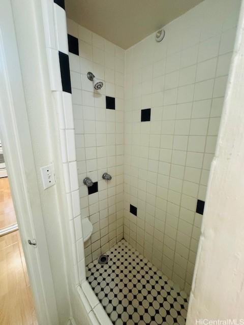 417 Nohonani St Unit 311, Honolulu, HI 96815 - bathroom featuring a tile shower and wood finished floors