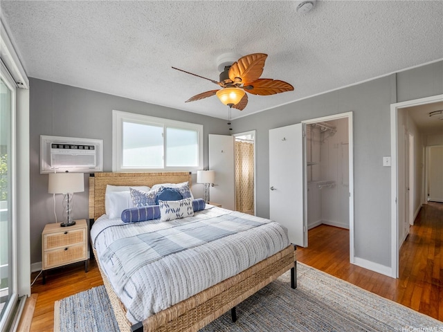 45-141A Kokokahi Pl, Kaneohe, HI 96744 - bedroom featuring wood finished floors, a spacious closet, a closet, a textured ceiling, and a wall mounted AC