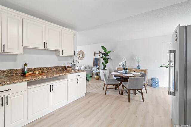 7528 Olili Pl, Honolulu, HI 96825 - kitchen featuring light wood-style floors, white cabinetry, dark stone countertops, and freestanding refrigerator