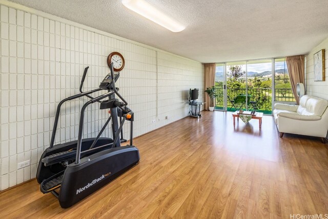 5095 Likini St Unit A301, Honolulu, HI 96818 - exercise area with a textured ceiling, wood finished floors, and expansive windows