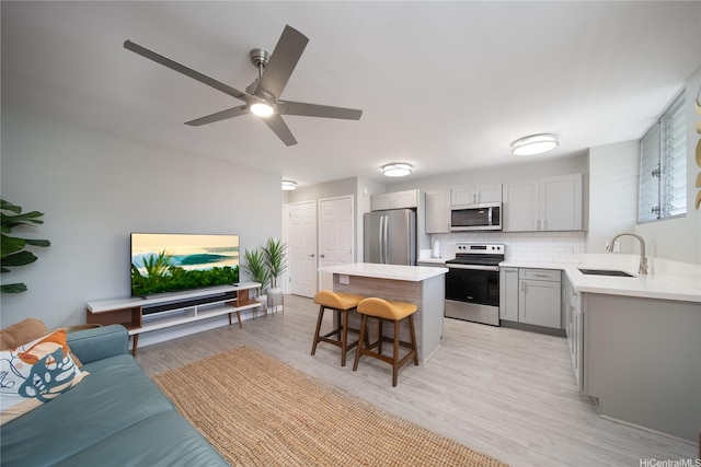1401 Lusitana St Unit 504, Honolulu, HI 96813 - kitchen featuring stainless steel appliances, a sink, gray cabinets, a breakfast bar area, and light countertops