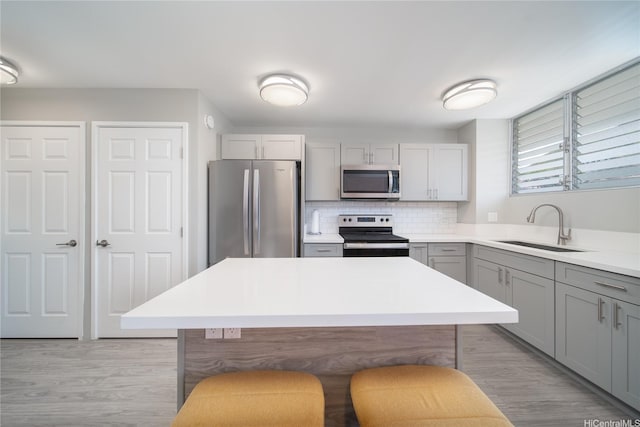 1401 Lusitana St Unit 504, Honolulu, HI 96813 - kitchen with stainless steel appliances, gray cabinets, a sink, light wood finished floors, and light countertops