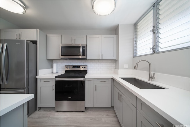 1401 Lusitana St Unit 504, Honolulu, HI 96813 - kitchen featuring stainless steel appliances, gray cabinets, a sink, backsplash, and light countertops