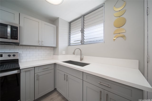 1401 Lusitana St Unit 504, Honolulu, HI 96813 - kitchen with stainless steel appliances, gray cabinets, a sink, tasteful backsplash, and light countertops