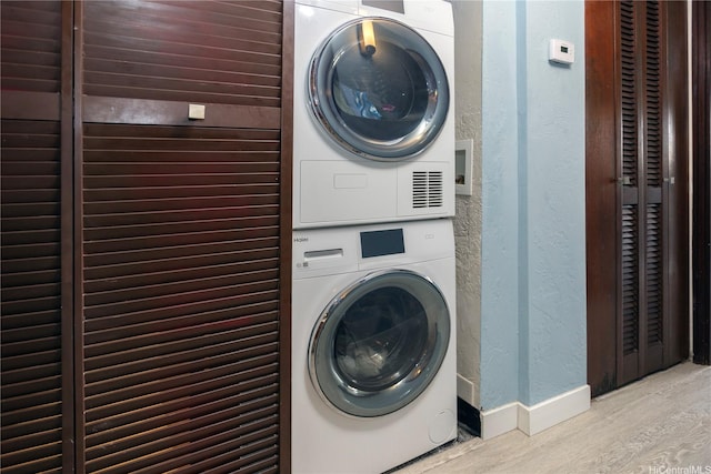 500 Lunalilo Home Rd Unit 22B, Honolulu, HI 96825 - laundry area with stacked washer / drying machine, wood finished floors, baseboards, and a textured wall