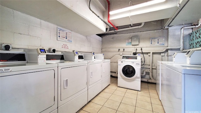 1850 Ala Moana Blvd Unit 222, Honolulu, HI 96815 - shared laundry featuring washing machine and clothes dryer, light tile patterned floors, and concrete block wall