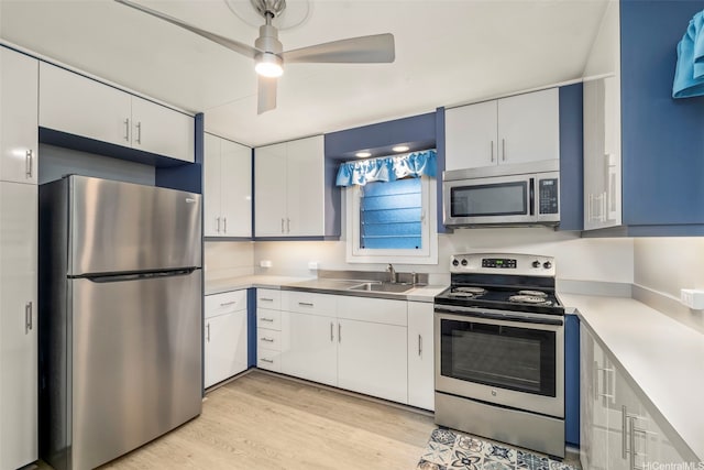1614 Hoolulu Rd, Wahiawa, HI 96786 - kitchen with appliances with stainless steel finishes, light countertops, light wood-style flooring, a ceiling fan, and white cabinets