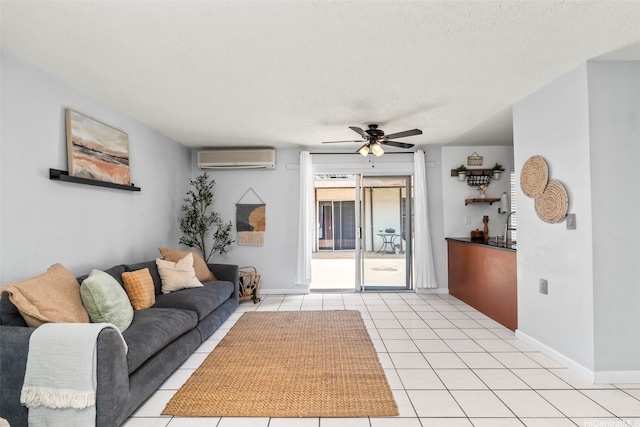 68-077 Au St Unit 2D, Waialua, HI 96791 - living area with ceiling fan, a wall unit AC, baseboards, light tile patterned flooring, and a textured ceiling