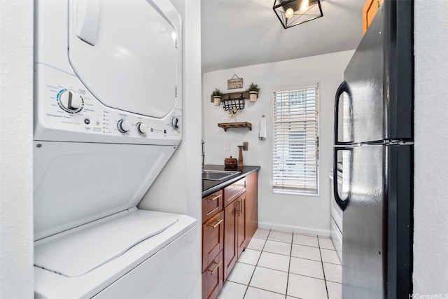 68-077 Au St Unit 2D, Waialua, HI 96791 - laundry area featuring stacked washer / drying machine, light tile patterned flooring, and baseboards