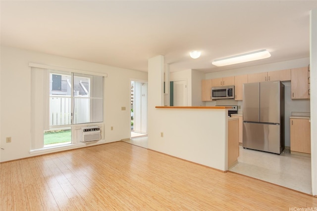 95-1025 Kaapeha St Unit 203, Mililani, HI 96789 - kitchen with appliances with stainless steel finishes, light wood finished floors, a wall mounted air conditioner, a peninsula, and light brown cabinets