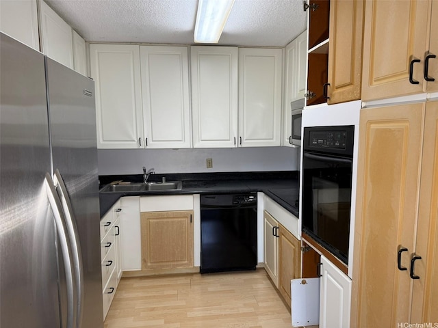 1717 Ala Wai Blvd Unit 306, Honolulu, HI 96815 - kitchen with black appliances, a sink, a textured ceiling, dark countertops, and light wood-style floors