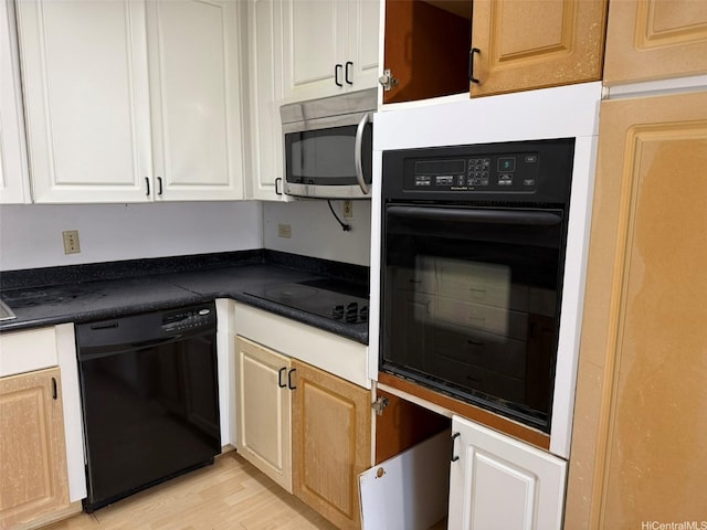 1717 Ala Wai Blvd Unit 306, Honolulu, HI 96815 - kitchen featuring black appliances, dark countertops, light wood-style flooring, and white cabinets