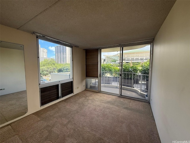 1717 Ala Wai Blvd Unit 306, Honolulu, HI 96815 - carpeted spare room with a textured ceiling, a wall of windows, and plenty of natural light
