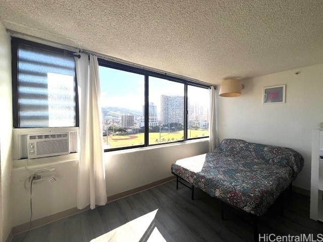 444 Niu St Unit 1312, Honolulu, HI 96815 - bedroom featuring wood finished floors, a textured ceiling, baseboards, and a view of city
