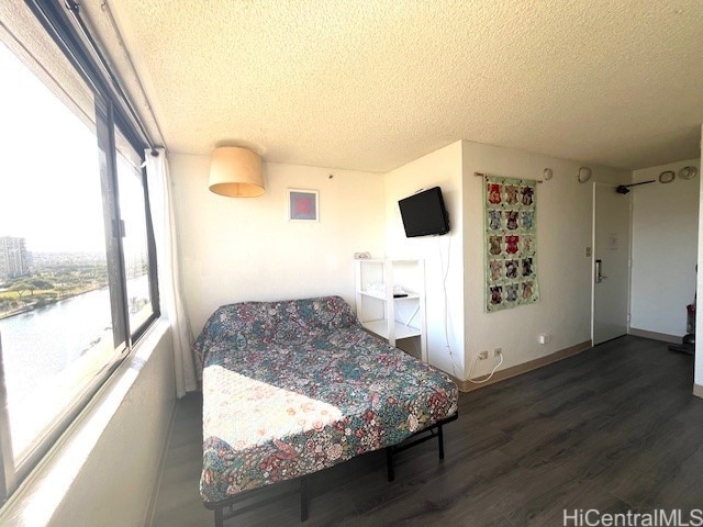 444 Niu St Unit 1312, Honolulu, HI 96815 - bedroom with a textured ceiling, wood finished floors, and baseboards