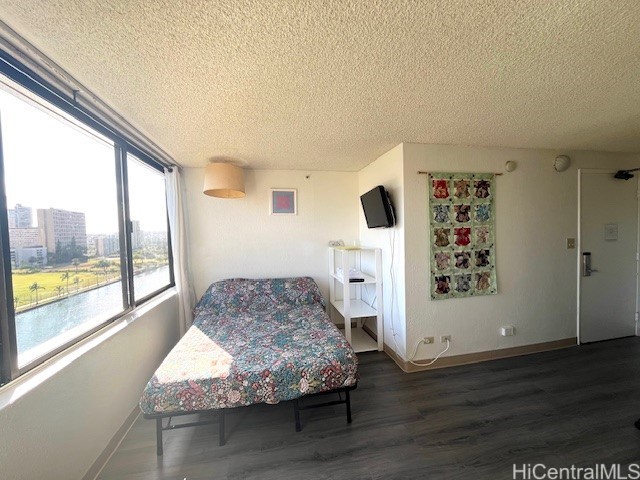 444 Niu St Unit 1312, Honolulu, HI 96815 - bedroom with a textured ceiling, wood finished floors, and baseboards