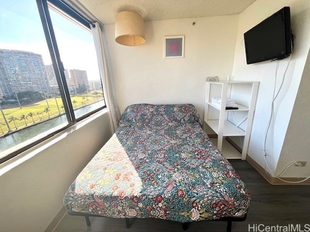 444 Niu St Unit 1312, Honolulu, HI 96815 - bedroom with wood finished floors, baseboards, a textured ceiling, and a city view