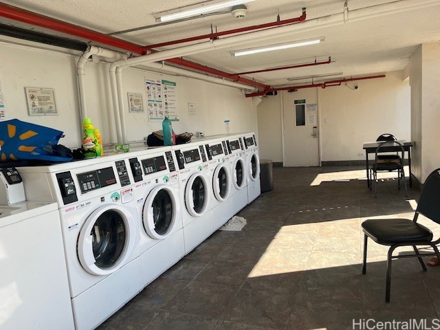 444 Niu St Unit 1312, Honolulu, HI 96815 - shared laundry room with washer and dryer and dark tile patterned floors
