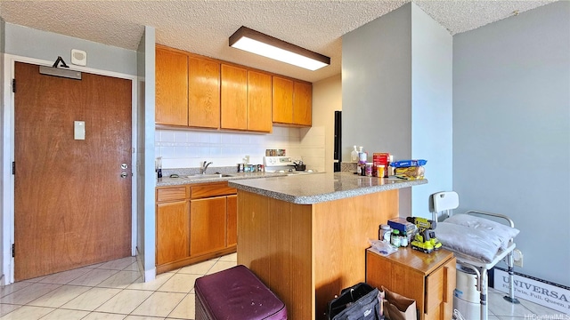 2040 Nuuanu Ave Unit 404, Honolulu, HI 96817 - kitchen with a sink, light tile patterned floors, a textured ceiling, a peninsula, and stove