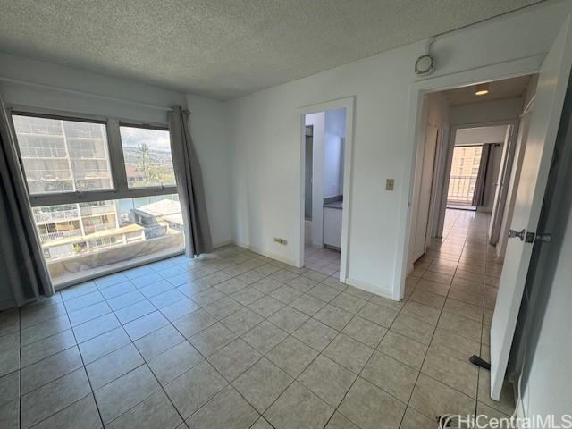 303 Liliuokalani Ave Unit 602, Honolulu, HI 96815 - unfurnished room with a textured ceiling and light tile patterned floors