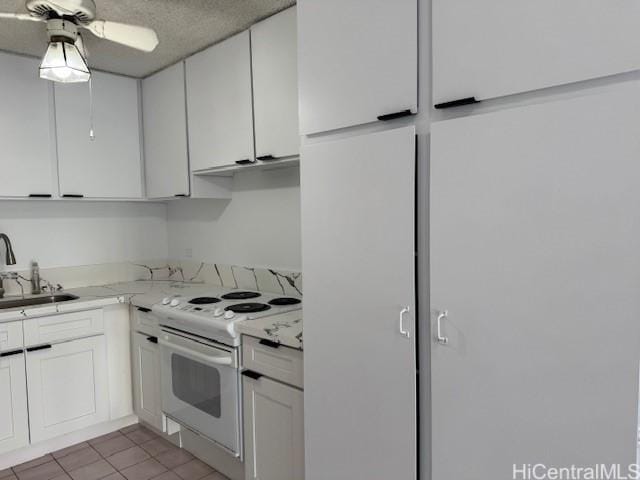303 Liliuokalani Ave Unit 602, Honolulu, HI 96815 - kitchen featuring white electric stove, a sink, white cabinets, ceiling fan, and tile patterned floors
