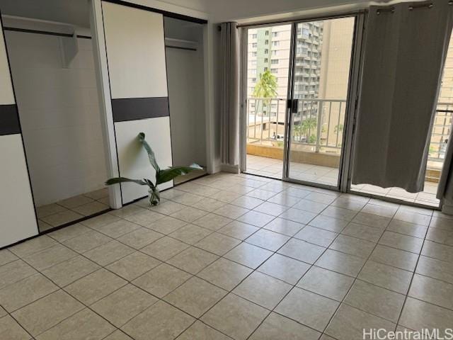 303 Liliuokalani Ave Unit 602, Honolulu, HI 96815 - unfurnished bedroom featuring light tile patterned floors, access to exterior, and multiple windows