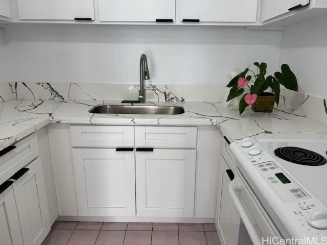 303 Liliuokalani Ave Unit 602, Honolulu, HI 96815 - kitchen featuring white electric stove, white cabinets, light tile patterned floors, and light stone counters