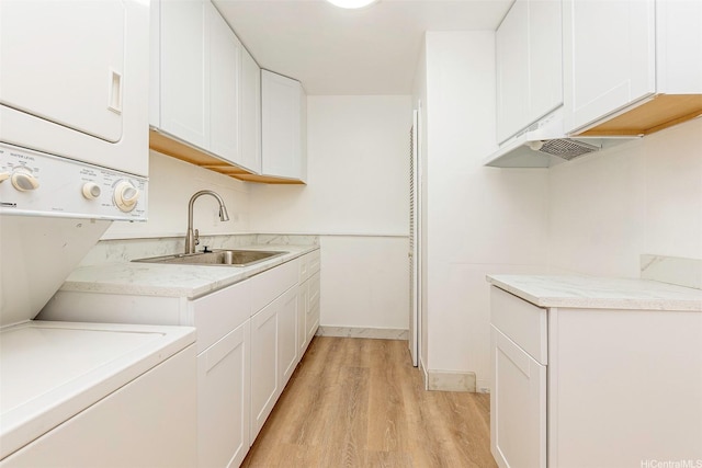 98-1040 Moanalua Rd Unit 1-201, Aiea, HI 96701 - washroom featuring stacked washer / dryer, light wood-style flooring, and cabinet space