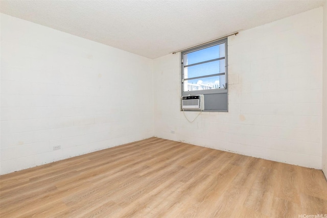 98-1040 Moanalua Rd Unit 1-201, Aiea, HI 96701 - empty room with wood finished floors, cooling unit, concrete block wall, and a textured ceiling