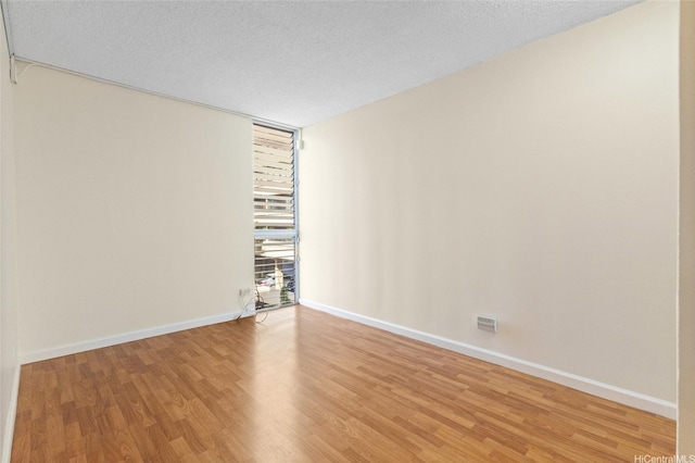 1050 Kinau St Unit 301, Honolulu, HI 96814 - empty room with light wood-style floors, baseboards, and a textured ceiling