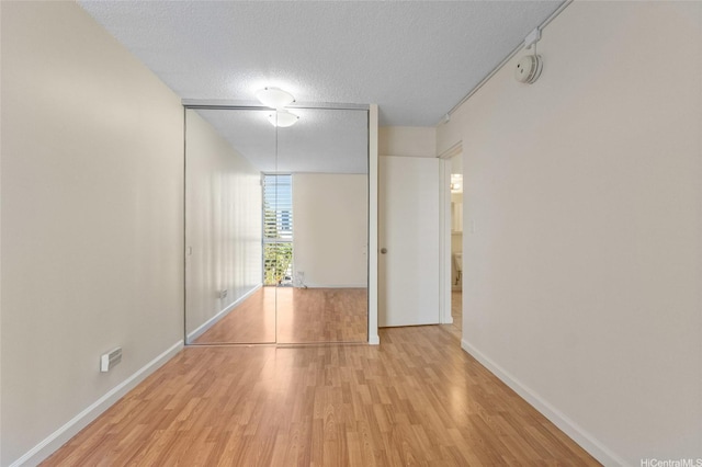 1050 Kinau St Unit 301, Honolulu, HI 96814 - unfurnished room with wood finished floors, a smoke detector, baseboards, and a textured ceiling