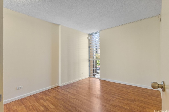 1050 Kinau St Unit 301, Honolulu, HI 96814 - spare room featuring wood finished floors, floor to ceiling windows, a textured ceiling, and baseboards