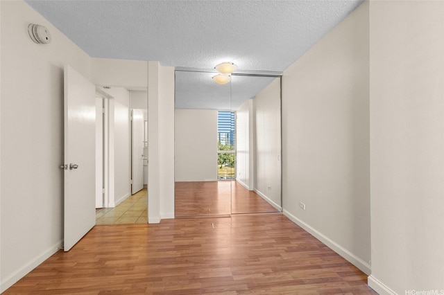 1050 Kinau St Unit 301, Honolulu, HI 96814 - unfurnished room with wood finished floors, a smoke detector, a textured ceiling, and baseboards