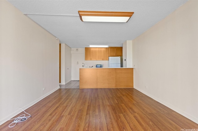 1050 Kinau St Unit 301, Honolulu, HI 96814 - unfurnished living room featuring wood finished floors, baseboards, and a textured ceiling