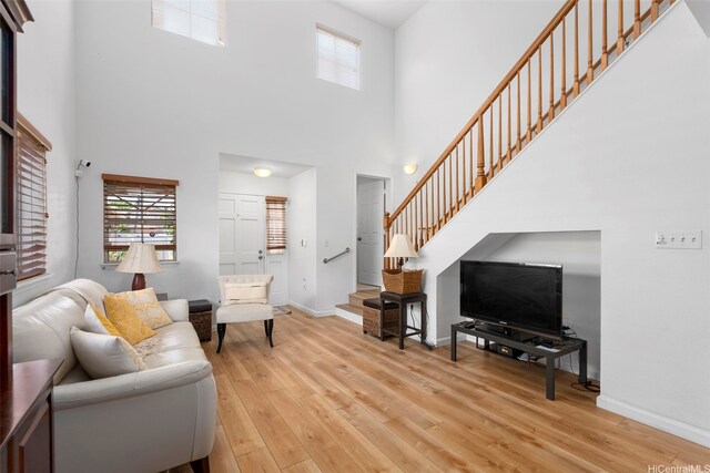 94-217A Kikepa Pl, Waipahu, HI 96797 - living room with stairway, a high ceiling, light wood-type flooring, and baseboards
