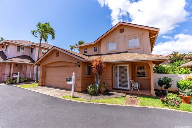 94-217A Kikepa Pl, Waipahu, HI 96797 - traditional home with stucco siding, an attached garage, asphalt driveway, and roof with shingles