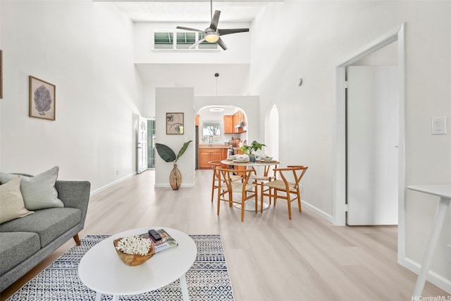 355 Aoloa St Unit D203, Kailua, HI 96734 - living area featuring arched walkways, light wood-type flooring, a ceiling fan, a high ceiling, and baseboards