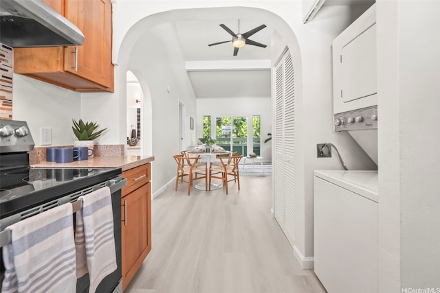 355 Aoloa St Unit D203, Kailua, HI 96734 - kitchen with stainless steel electric stove, under cabinet range hood, stacked washing machine and dryer, light wood finished floors, and a ceiling fan