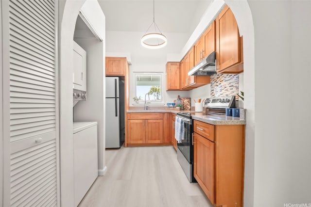 355 Aoloa St Unit D203, Kailua, HI 96734 - kitchen with stainless steel appliances, under cabinet range hood, estacked washer and dryer, light wood-style flooring, and arched walkways