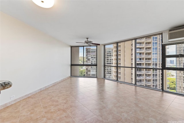 2101 Nuuanu Ave Unit I-1002, Honolulu, HI 96817 - spare room featuring floor to ceiling windows, a ceiling fan, tile patterned flooring, a wall mounted AC, and baseboards