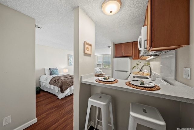 1060 Kamehameha Hwy Unit 4204A, Pearl City, HI 96782 - kitchen with freestanding refrigerator, brown cabinetry, a sink, light countertops, and a kitchen breakfast bar