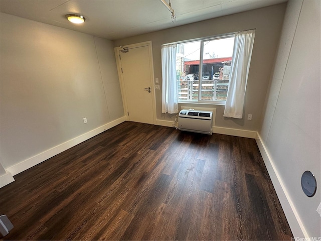 803 Waimanu St Unit 109, Honolulu, HI 96813 - unfurnished room with an AC wall unit, dark wood-style flooring, and baseboards