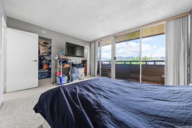 94-402 Kapuahi St Unit 46, Mililani, HI 96789 - carpeted bedroom featuring access to exterior, a textured ceiling, a walk in closet, and a wall of windows