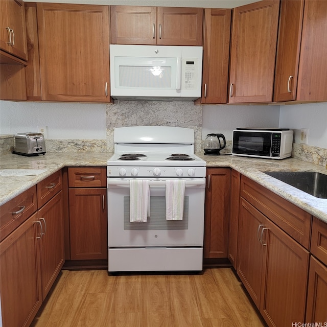 95-1050 Makaikai St Unit 16C, Mililani, HI 96789 - kitchen featuring white appliances, brown cabinets, and light wood-type flooring