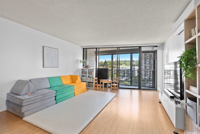 98-501 Koauka Loop Unit A704, Aiea, HI 96701 - living area with light wood-style flooring, a textured ceiling, and a wall of windows