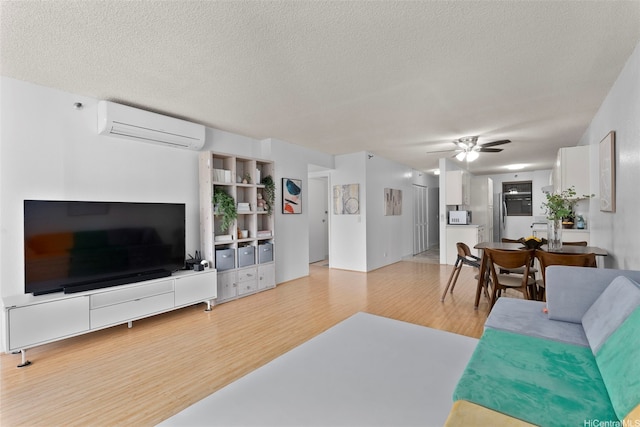 98-501 Koauka Loop Unit A704, Aiea, HI 96701 - living area with a wall unit AC, wood finished floors, ceiling fan, and a textured ceiling