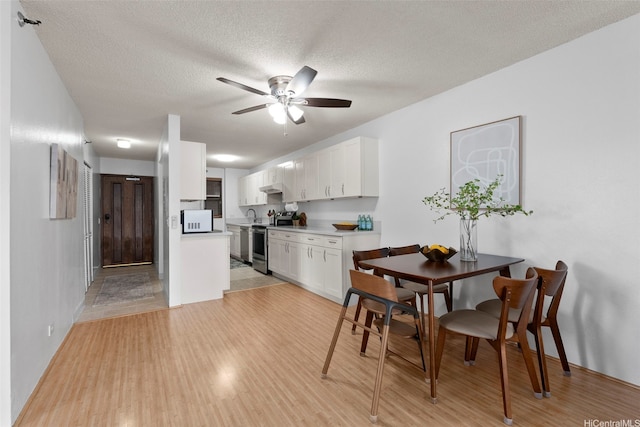 98-501 Koauka Loop Unit A704, Aiea, HI 96701 - dining room with a ceiling fan, light wood-style flooring, a textured ceiling, and baseboards
