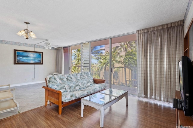2115 Ala Wai Blvd Unit 501, Honolulu, HI 96815 - living area with a textured ceiling, baseboards, a wall of windows, a chandelier, and wood finished floors