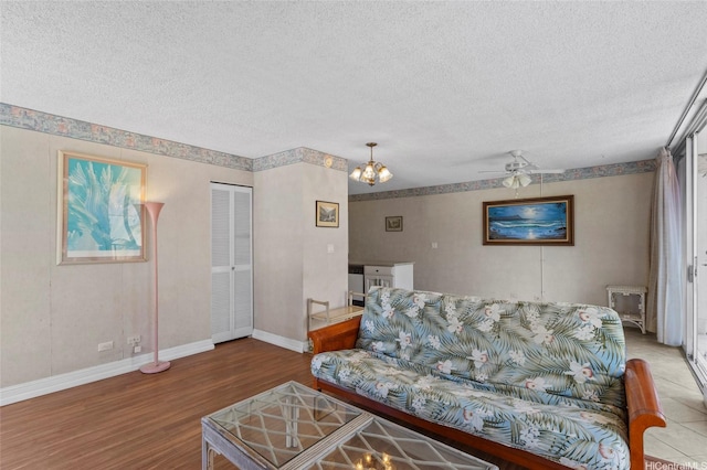 2115 Ala Wai Blvd Unit 501, Honolulu, HI 96815 - living room featuring wood finished floors, a textured ceiling, baseboards, ceiling fan, and a chandelier